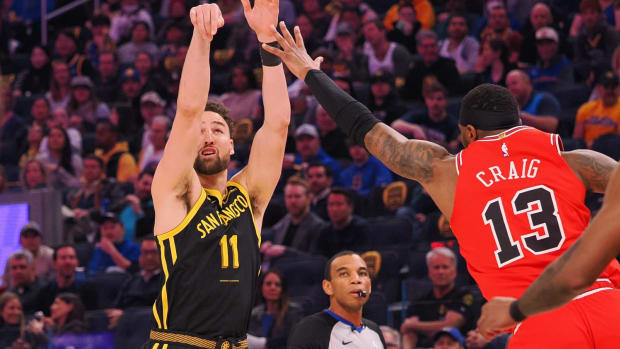 Golden State Warriors guard Klay Thompson (11) scores a three-point basket against the Chicago Bulls forward Torrey Craig (13) during the first quarter at Chase Center.
